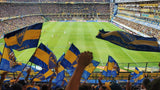 Fans of Boca Juniors wave blue and yellow flags in the stands of the Bombonera stadium