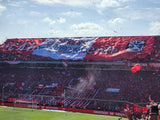 Independiente fans unfurl a large telón banner in the popular of the Ricardo Bochini stadium