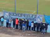 Local fans chanting and waving flags at an Ascenso game